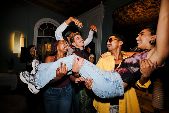 Cheerful young people celebrating together at house party