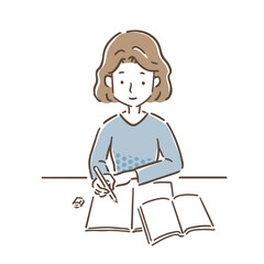 机にノートとテキストを広げて勉強をしている若い女性