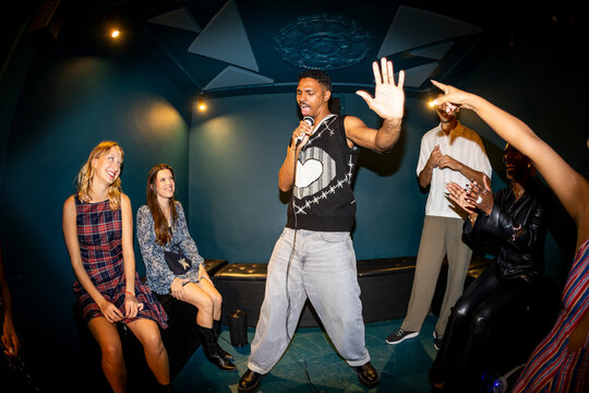 Man singing in karaoke with friends
