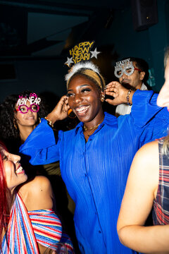 Woman with Happy New Year tiara at nightclub party