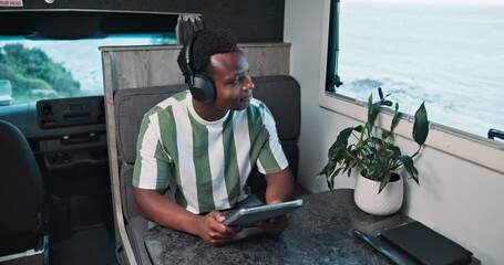 Headphones, choice or black man in caravan with tablet, streaming or listening to song on road trip. Happy, music option or male person in trailer with tech, album or radio subscription on journey.