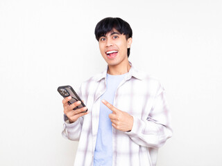 Young man showing an excited reaction while pointing at his smartphone, expressing joy and enthusiasm in a bright, clean setting.