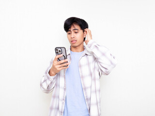 Young man looking stressed and confused while checking his smartphone on a clean white isolated background.