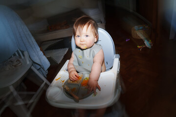 Baby Enjoying Messy Meal in High Chair at Home