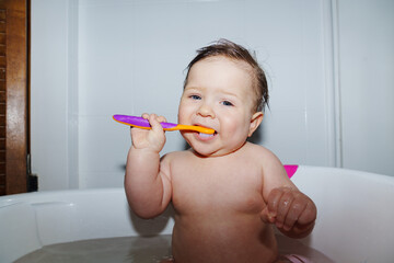 Baby Enjoys Bath Time While Brushing Teeth With Colorful Toothbrush