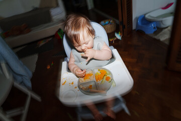 Toddler Eats Colorful Food While Enjoying Mealtime at Home