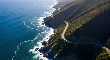 Aerial view of a winding coastal road along a rugged cliffside with ocean waves.