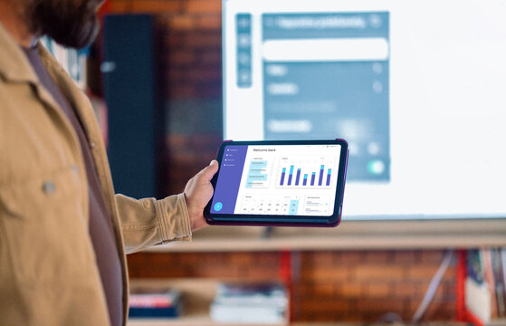 Person Holding Tablet With Data Dashboard During Presentation