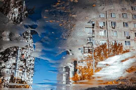 Reflection of buildings in a water puddle