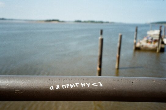 Handwritten message on a rusty seaside railing