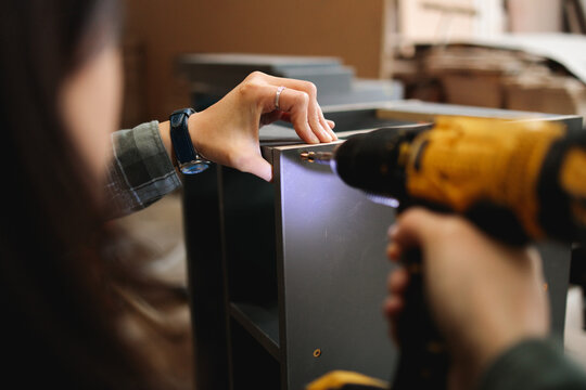 Close-Up of Woman Drilling Cabinet Corner