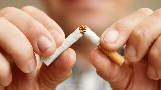 A person snapping a cigarette in two, quit smoking.