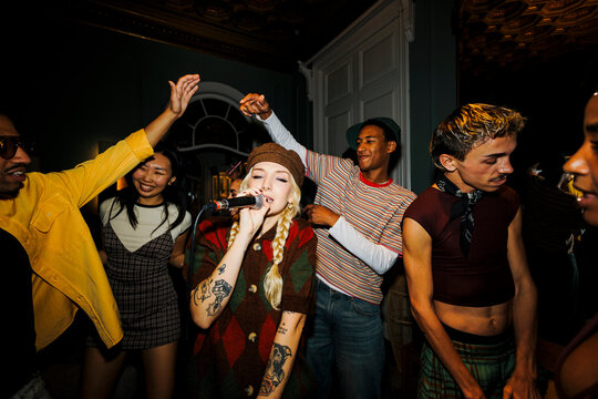 Diverse friends enjoying karaoke singing at a party