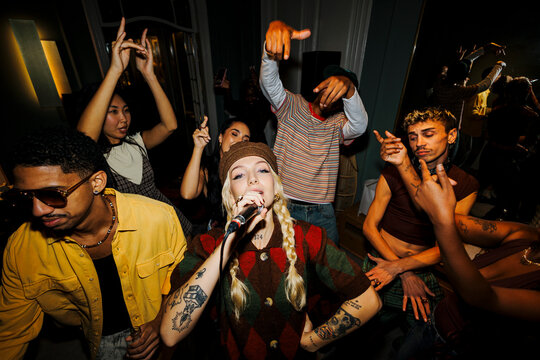 Young woman singing into microphone performing live music