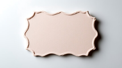 Fototapeta premium A decorative, scalloped-edge frame with a soft, pale pink background, set against a white backdrop. The frame has a gentle, wavy pattern that adds a touch of elegance and charm.