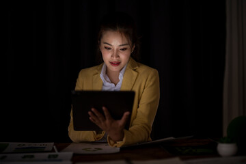 Businesswoman working overtime late night using tablet