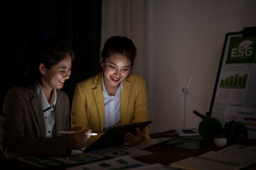 Businesswomen collaborating on esg reports late night