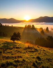 Golden sunrise over misty green hills and majestic mountain range