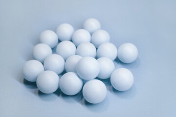 Soft blue spheres arranged closely together on a light surface 