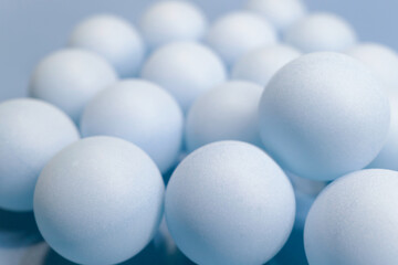 Soft blue spheres arranged closely together on a light surface 