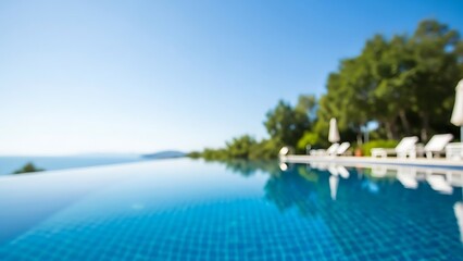 Obraz na płótnie Canvas Blurred luxury infinity pool with panoramic ocean view under a clear blue sky, ideal for relaxation concepts