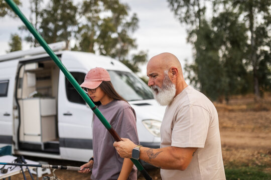 Father and daughter fishing together by the river
