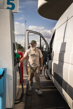 Mature man refueling his van at a gas station