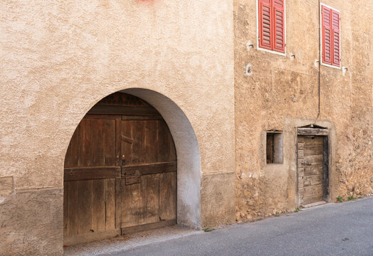 Rustic Wooden Arch Door in Weathered Stucco Wall