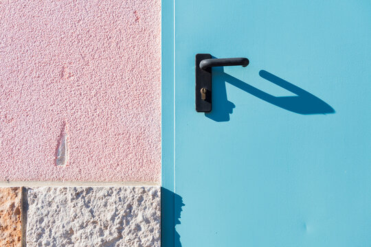 Blue Door Pink Wall and Black Handle Shadow