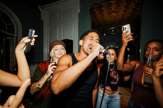 Friends enjoying karaoke night singing and having fun