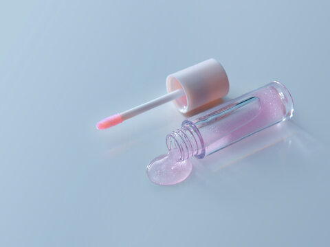 Lip gloss with a pink tint and applicator on a light surface.