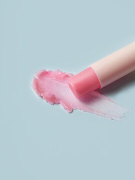Lip balm application on a light blue surface