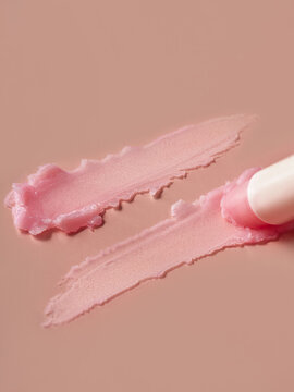 Lip balm application on a pink surface