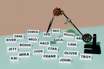 mechanical clamps holding a printed baby name among other names