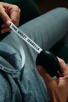 close-up of a man holding a label printer with baby names