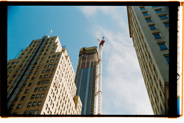 Workers Construct a Tall Building in a Busy Urban Area