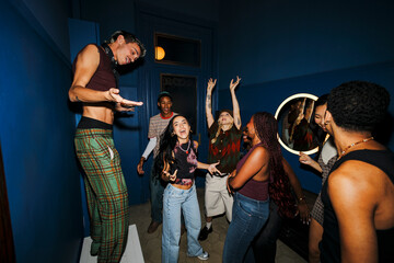 Diverse young friends dancing and having fun at house party