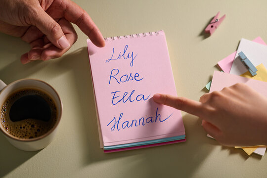 Hands pointing at a notepad with names