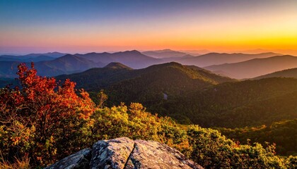 Panoramic view of mountain ranges at dusk, bathed in warm sunset hues