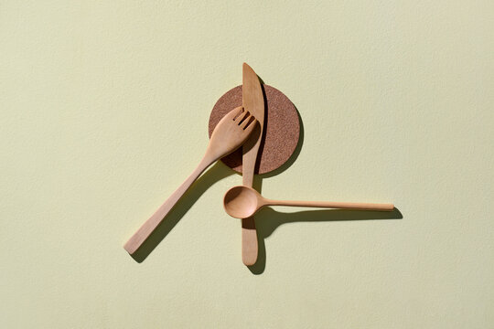 Wooden cutlery arranged on a light green background