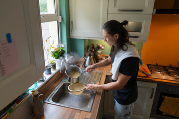 Young Man Strains Pasta in a Cozy Kitchen at Home