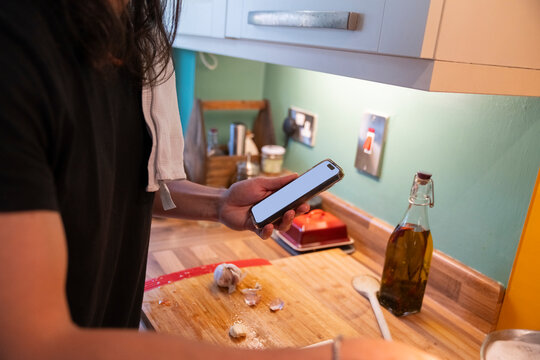 Relax Man Cooks Homemade Pasta While Checking Phone for Recipe Updates
