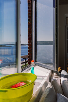 Cleaning Supplies on Windowsill with Open Window and Lake View