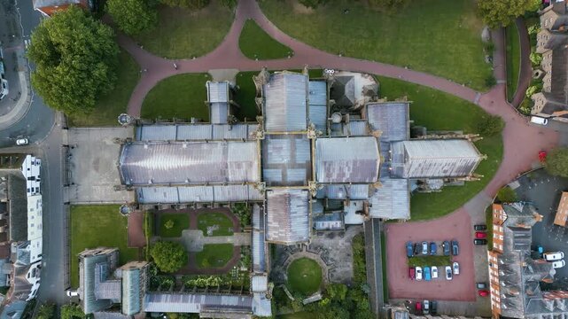 Top down drone shot rising above the Hereford Cathedral, golden hour in UK