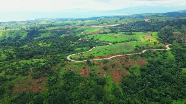 A forward aerial moving along winding roads through lush green hills and dense vegetation, gradually revealing the expansive rural terrain in Quinawan mountain view, Mariveles Bataan, Philippines