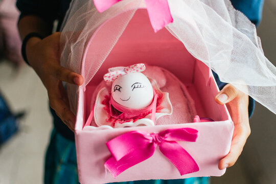 Hands holding adolescent maternity school project cradle