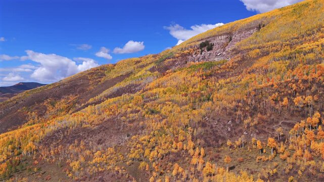 Vail Valley Vail Village Gore Range Vail Pass Avon aerial drone Colorado fall autumn Rocky Mountains hillside cliffs quaking Aspen Trees morning blue sky cliffs Piney Ranch circle left motion