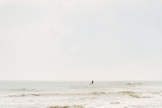 Paddleboarder gliding across gentle ocean waves