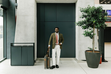 Stylish Traveler Standing With Suitcase in Modern Airport Setting