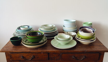 Variety of colorful plates and bowls arranged on a wooden table